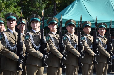 Funkcjonariusze kompanii reprezentacyjnej sg stoją w szpalerze na baczność, trzymając w rękach długie karabiny