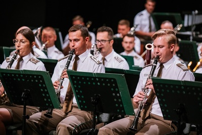 funkcjonariusze straży granicznej grający w orkiestrze reprezentacyjnej straży granicznej podczas koncertu. na pierwszym planie pokazani są klarneciści.