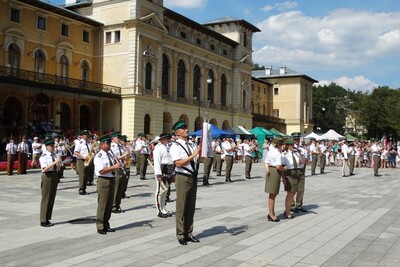 orkiestra reprezentacyjna straży granicznej pokazuje układ musztry paradnej. funkcjonariusze wykonują różne figury  w połączeniu z muzyką.