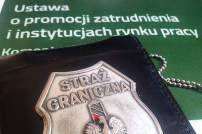 legitymacja straży granicznej z widocznym orłem oraz słupkiem granicznym nad którymi znajduje sie napis Straż graniczna. legitymacja położona jest na Ustawie o promocji zatrudnienia.