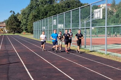 funkcjonariusze zaliczają Test Coopera. biegają na bieżni sportowej. na sobie mają strój do wykonywania ćwiczeń.