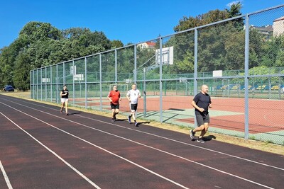 funkcjonariusze zaliczają Test Coopera. biegają na bieżni sportowej. na sobie mają strój do wykonywania ćwiczeń.