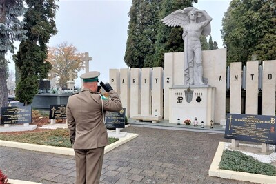 funkcjonariusz sg oddaje honor przed pomnikem w kwaterze wojennej na cmentarzu w Końskcih