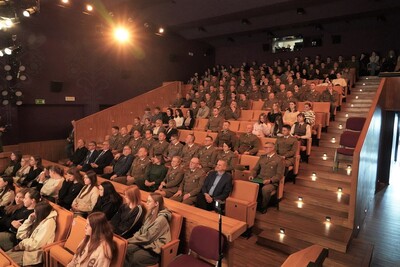 na zdjęciu widoczna publiczność zebrana w sali kinowej podczas projekcji filmu o generale Kruszewskim. obecni są funkcjonariusze straży granicznej oraz osoby cywilne.