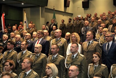 Widok publiczności w tym oficjeli zasiadających w sali kinowej. Widok w skos od sceny.