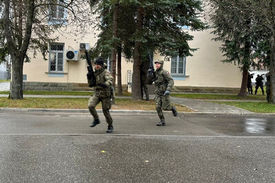 dwóch żołnierzy biegnie przed siebie aby szybko wejść do budynku. w tle, żołnierze którzy ich osłaniają .