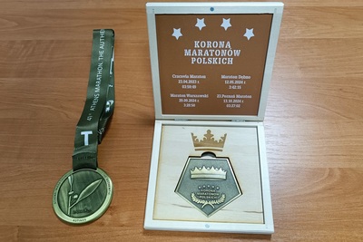 na blacie leży medal ukończenia maratonu ateńskiego oraz kasetka z medalem ukończenia korony maratonów polskich