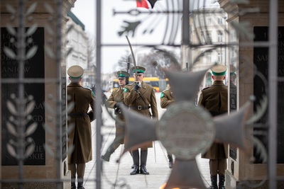 na zdjęciu dowódca kompani honorowej który oddaje honor przed grobem nieznanego żołnierza w warszawie. w dłoni trzyma szable w postawie na baczność.