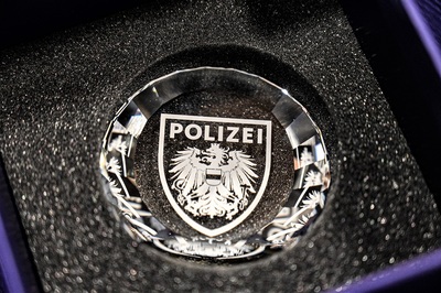 w granatowym etui pamiątkowy kryształ w okrągłym kształcie z napisem polizei otrzymany od policjantów z austrii