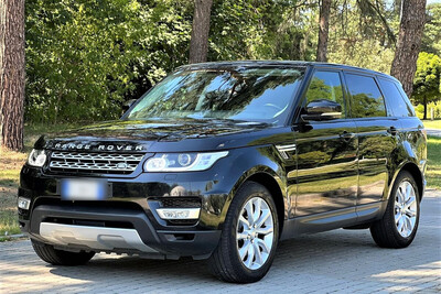 Parking na zewnątrz . Jeden z odzyskanych luksusowych samochodów marki  Land Rover, kolor czarny - widok z przodu.