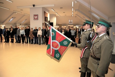 Sala odpraw, na pierwszym planie poczet sztandarowy ze sztandarem kaosg. w tle pracownicy KaOSG - uczestnicy uroczystości.