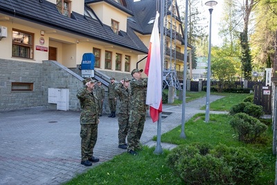 poczet flagowy składający się z funkcjonariuszy straży granicznej zakłada flage polski na masz, w tle widać budynek straży granicznej