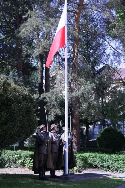 poczet flagowy straży granicznej oddaje honor szablami fladze polski