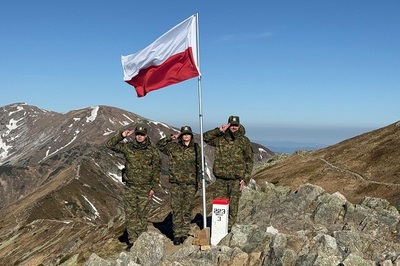 funkcjonariusze straży granicznej oddają honor fladze polski w tle widać szczyty gór wysokich