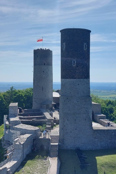 flaga polski zawieszona na jedej z dwóch baszt zamkowych