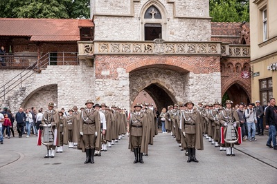 Orkiestra reprezentacyjna straży granicznej stoi przed występem przed Barbakanem w Krakowie. Funkcjonariusze ubrani w mundur wyjściowy