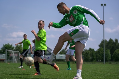 piłkarz w zielonym stroju podczas uderzenia piłki w stronę bramki