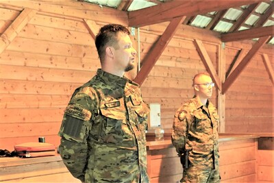 Dwóch funkcjonariuszy prowadzących zajęcia stoi. jeden omawia zasady obowiązujące na szkoleniu