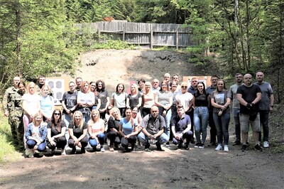 Zdjęcie grupowe uczestników szkolenia ze strzelania i pierwszej pomocy przedmedycznej. Grupa ponad 30 osób. Towarzyszą im instruktorzy.