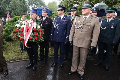 Na zdjęciu przedstawiciele służb mundurowych przygotowują się do składania wieńców pod pomnikiem.