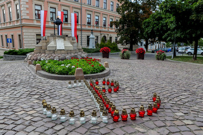 1.	Na zdjęciu Grób Nieznanego Żołnierza w Tarnowie, przed którym miały miejsce obchody 81. rocznicy wybuchu Powstania Warszawskiego. Przed pomnikiem ułożony z ciało – czerwonych zniczy znak Polski Walczącej . W tle widocznie biało- czerwone flagi orz budynek.