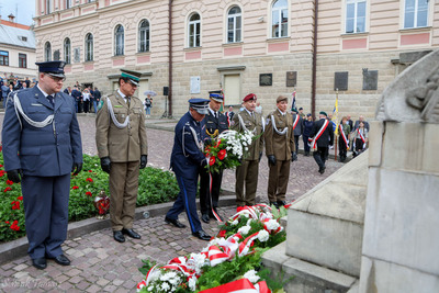 Na zdjęciu przedstawiciele służb mundurowych składają wieńce przed Grobem Nieznanego Żołnierza w Tarnowie. W tle widoczne poczty sztandarowe oraz mieszkańcy miasta.