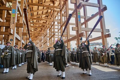 Trzech muzyków Orkiestry Reprezentacyjnej SG gra na długich, drewnianych trąbach (bazunach) w pawilonie Expo.