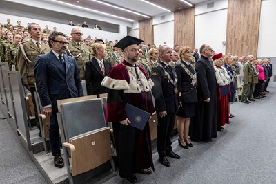 widok na aule wssg. przy fotelach umieszczonych z góry na dół stoją uczestnicy uroczystości, rektorzy, studenci, zaproszeni goście