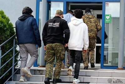 Zatrzymanych trzech hindusów zostaje wprowadzanych po schodach do siedziby placówki sg w krakowie przez dwóch umundurowanych funkcjonariuszy sg