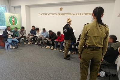 Wszyscy zatrzymani cudzoziemcy siedzą na krzesłach w siedzibie placówki sg w krakowie, kilku czyta wręczone im decyzje, pozostali siedzą. Wszyscy sa pilnowani przez dwie funkcjonariuszki sg umundurowane