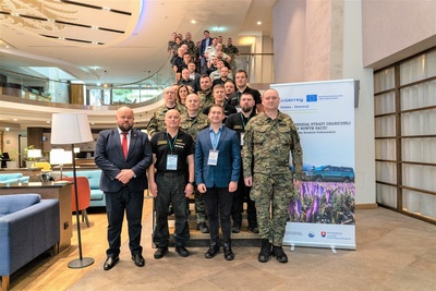 Uczestnicy szkolenia stoją na pamiątkowym zdjęciu. Ustawili się na schodach. W tle wnętrze hotelu.