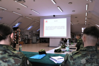 na ekranie wyświetla się prezentacja o krwiodawstwie. przyglądają się jej funkcjonariusze sg siedzący w przyciemnionej sali odpraw.