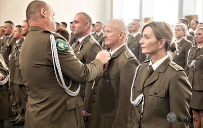 hala sportowa. generał przypina medal odznaczonym funkcjonariuszom.