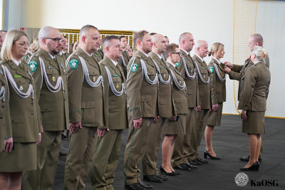 hala sportowa. generał przypina medal odznaczonym funkcjonariuszom.