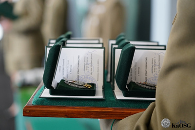 zbliżenie na tacę na której położone są odznaki sg oraz legitymacje