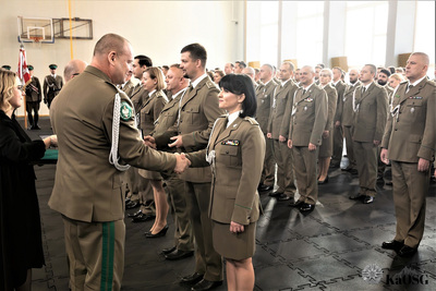 Hala sportowa. generał gratuluje awansu na wyższy stopień służbowy mianowanym funkcjonariuszom.