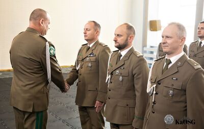 Hala sportowa. generał gratuluje awansu na wyższy stopień służbowy mianowanym funkcjonariuszom.