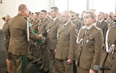 Hala sportowa. generał gratuluje awansu na wyższy stopień służbowy mianowanym funkcjonariuszom.