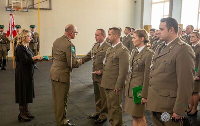Hala sportowa - przedstawiciel hdk wręcza odznaki zasłużonego dawcy krwi jednej kobiecie i trzem mężczyznom