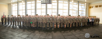 zdjęcie panoramiczne zrobione na hali sportowej. obejmuje wszystkich uczestników uroczystości wraz z pocztem sztandarowym kaosg i kadrą kierowniczą - kilkaset osób