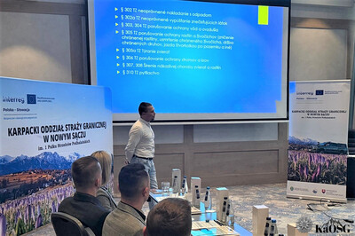 uczestnicy spotkania - siedzą przy stole ułożonym w kształcie litery u. słuchają prelegenta.