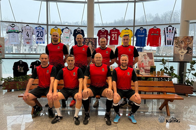 Zawodnicy Karpackiego Oddziału Straży Granicznej w czerwono-czarnych koszulkach reprezentacyjnych oddział na tle przedmiotów przeznaczonych do licytacji