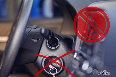 Na zdjęciu wnętrze samochodu z widoczną kierownicą i stacyjką, w której kluczyki są przekroczone symbolicznym, czerwonym krzyżykiem . U góry widoczny czerwony znaczek z przekreśloną symboliczną butelką prawdopodobnie alkoholu.