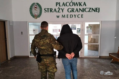 funkcjonariusz Straży Granicznej prowadzi zatrzymanego do placówki SG w Medyce