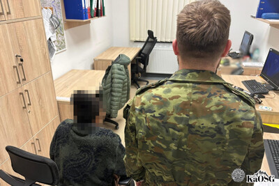 zatrzyamana obywatelka usa siedzi w pomieszczeniu biurowym. towarzyszy jej obrócony tyłem funkcjonariusz sg