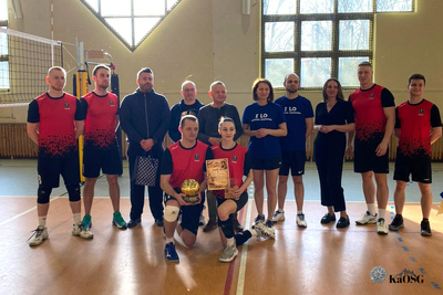 Na zdjęciu widać drużynę sportowcy ubrani w sportowe ciuchy. Zdjęcie zrobione na hali sportowej