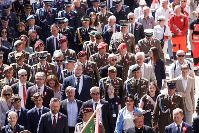 tłum uczestników uroczystości 3 majowych idzie w patriotycznym pochodzie ulicami krakowa