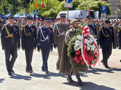 szefowie służb mundurowych w małopolsce idą za wieńcem niesionym przez mundurowego