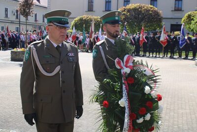 dwóch funkcjonariuszy składa wieniec pod pomnikiem