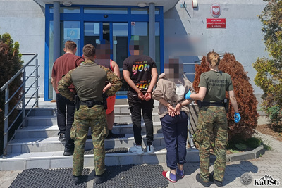 Funkcjonariusze placówki sg w krakowie wprowadzają do siedziby placówki kilku zatrzymanych cudzoziemców